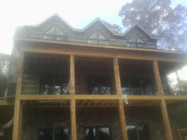 Dormers and porch framing on a large log home under construction in Petersburg